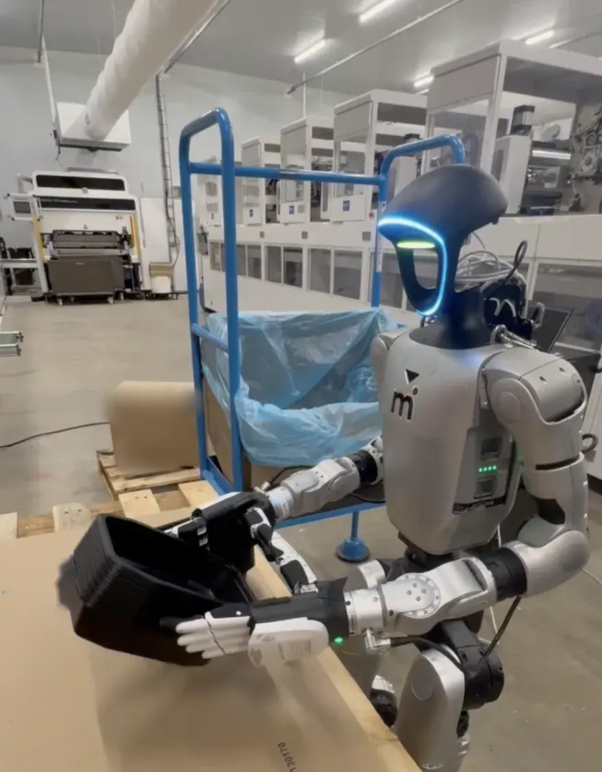 A Motion humanoid handling trays on a live pilot line.